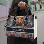 Lion portrait handbag carried outdoors by top handles showing the lion face and floral artwork.
