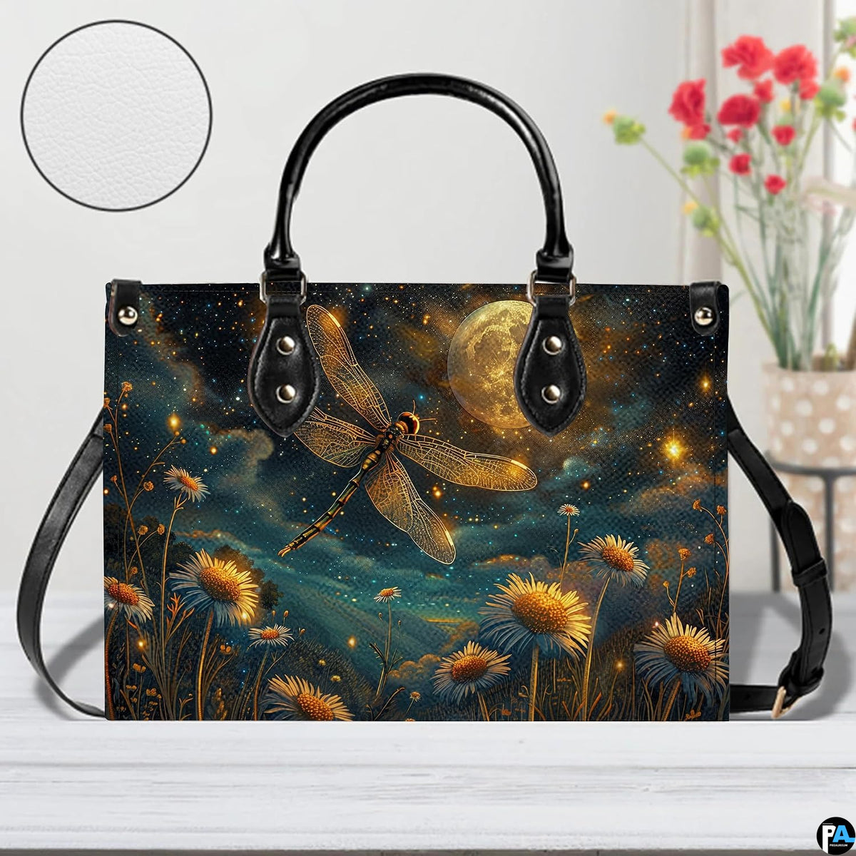 Front view of celestial dragonfly handbag on white table with floral vase and texture swatch inset