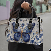 Street lifestyle view of Delftware floral butterfly handbag held by hand on sidewalk