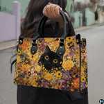 Model walking outdoors holding the black cat Gustav Klimt inspired floral printed creation.
