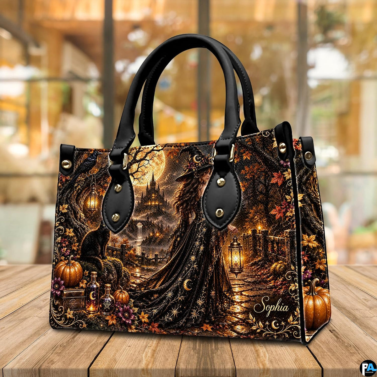 Gothic witch handbag and wallet displayed on wooden table beside potted plant.