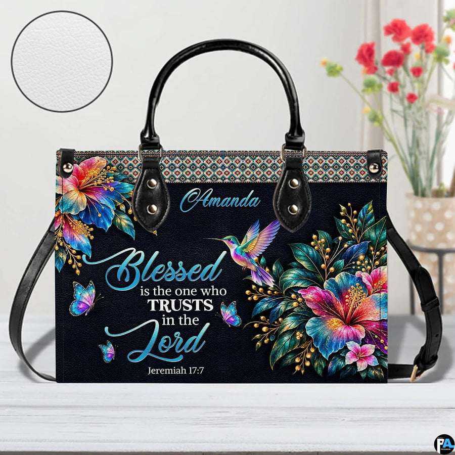 Hummingbird handbag on white table beside floral bouquet with texture swatch inset.