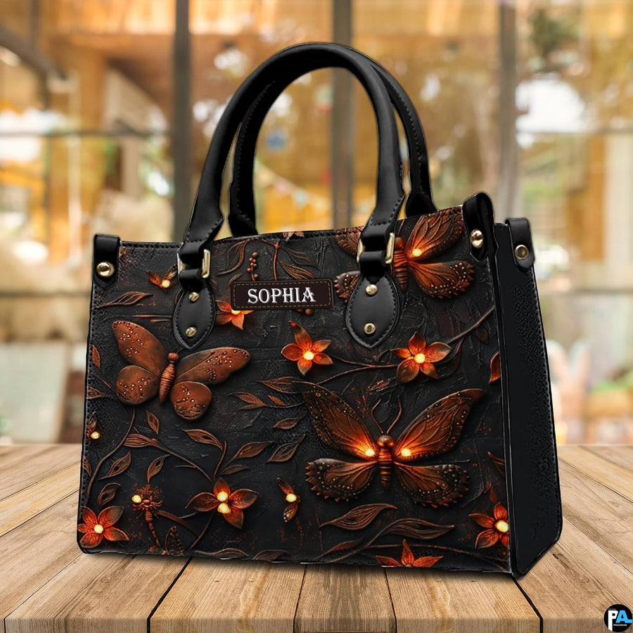 Luminous firefly handbag displayed on an outdoor wooden deck with bright cafe windows in view.