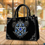 Silver pentagram handbag displayed on wooden tabletop in front of cafe window.
