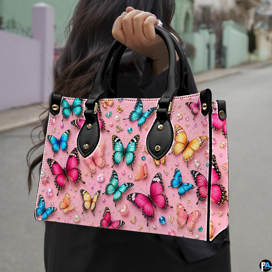 Outdoor street perspective showing colorful butterfly artwork held by pedestrian along town sidewalk.