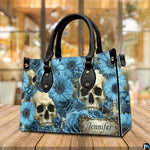 Skull floral daisy handbag displayed on wooden plank table before indoor window.