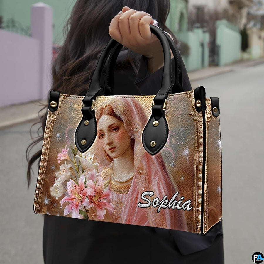 Model carrying Virgin Mary and blooming lilies devotional handbag outdoors