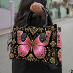 Outdoor street perspective showing pink jeweled butterfly artwork held by pedestrian along town sidewalk.