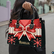 Christmas bow handbag displayed alongside matching wallet with red ribbon bow and snowflake motif.