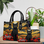 Tabletop presentation highlighting cat landscape art resting beside leafy indoor greenery.