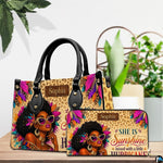 Tabletop presentation showing the feathered woman artwork and coordinating accessory near potted plants.