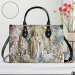 Tabletop display of pearl Madonna handbag showcasing pastel blossoms and golden leaves