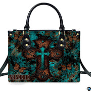 Side profile view of structured turquoise cross butterfly handbag.
