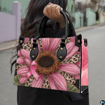 Street lifestyle perspective featuring pink sunflower art accessory held outdoors in natural daylight.