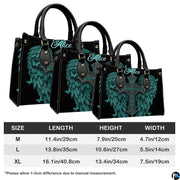 Top-down view of turquoise angel wings cross handbag showing dual carrying handles.