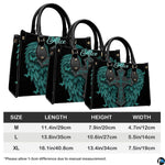 Top-down view of turquoise angel wings cross handbag showing dual carrying handles.