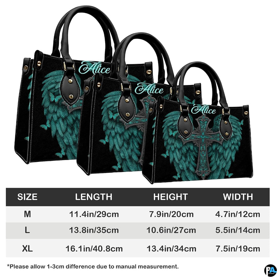 Top-down view of turquoise angel wings cross handbag showing dual carrying handles.