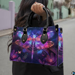 Front view of glowing neon dragonfly handbag with vivid magenta and cyan wings on deep purple