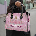 Front view of unicorn handbag displaying pink rose crown, golden horn, and curved eyelashes.
