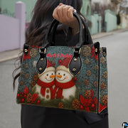 Angle perspective showing festive snowman couple artwork wrapping across handbag and matching wallet