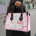 Angled view of pink doctor handbag showcasing clinical coat illustration and black top handles