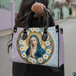 Angled view of pastel daisy wreath Virgin Mary handbag