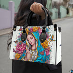 Outdoor lifestyle photo of praying Madonna handbag carried over the arm on an urban street.