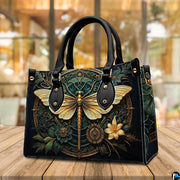 Side profile of gold dragonfly handbag showing continuous botanical medallion print along gusset
