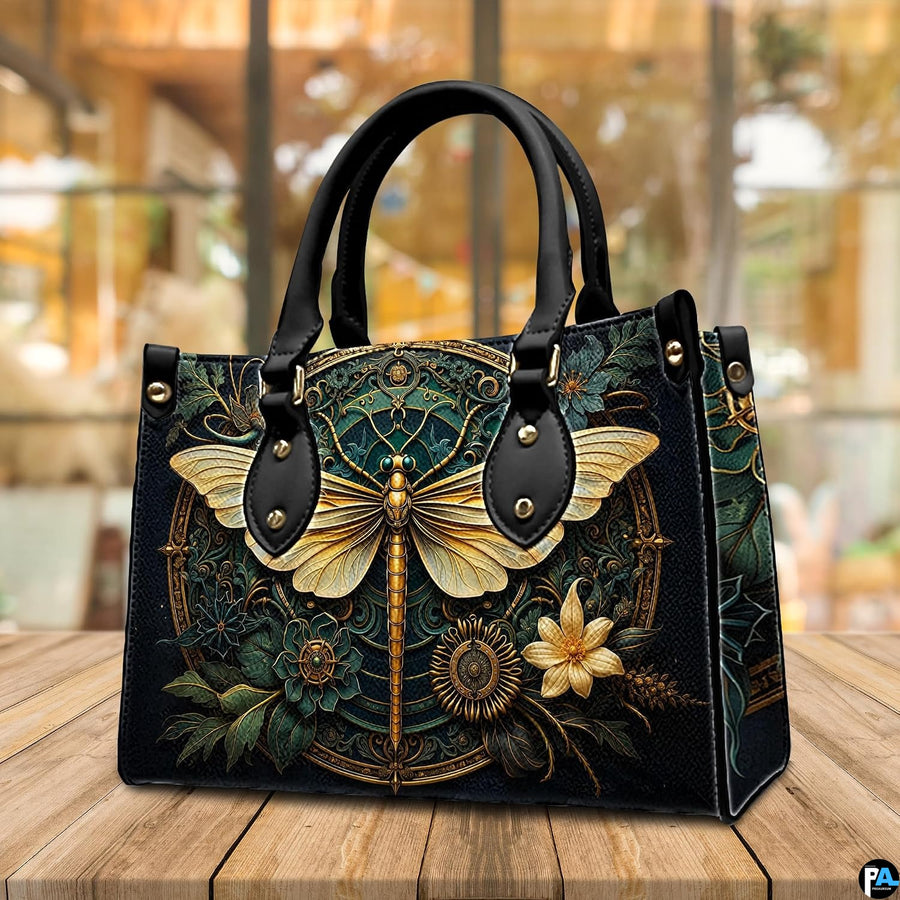 Side profile of gold dragonfly handbag showing continuous botanical medallion print along gusset
