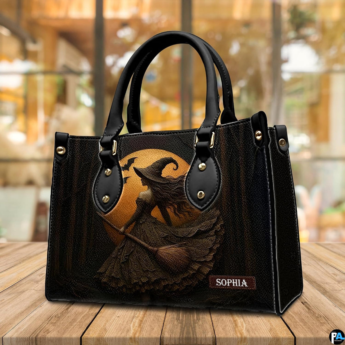 Gothic witch handbag displayed on wooden tabletop in front of sunlit window.