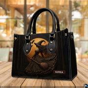 Gothic witch handbag displayed on wooden tabletop in front of sunlit window.