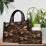 Bronze dragonfly handbag and matching wallet arranged together on a wooden tabletop near houseplants.