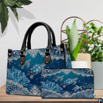 Side view of structured sea turtle handbag displaying sleek profile and black carrying handles.
