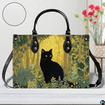 Studio perspective of black cat woodland design resting on white painted wood beside floral blossoms.