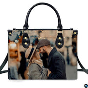 Demonstration of romantic couple portrait artwork on upright handbag with bokeh city lights.