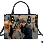 Demonstration of romantic couple portrait artwork on upright handbag with bokeh city lights.