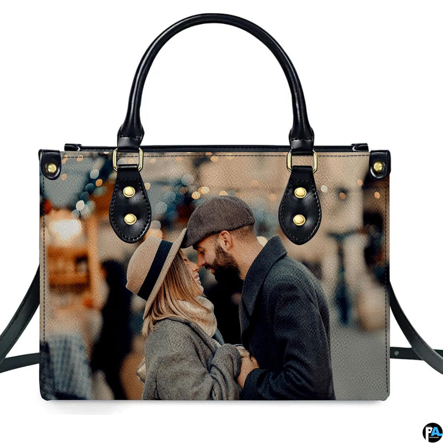 Demonstration of romantic couple portrait artwork on upright handbag with bokeh city lights.
