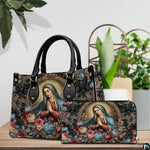 Tabletop lifestyle display showing baroque Madonna handbag and matching wallet beside potted house greenery.