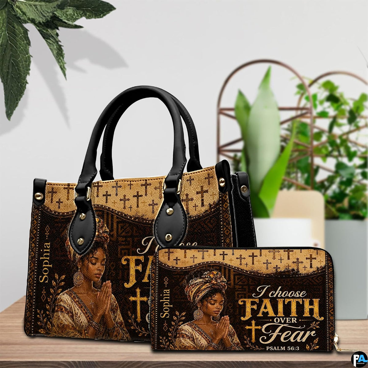 Handbag and wallet set displayed on wooden tabletop with green plant