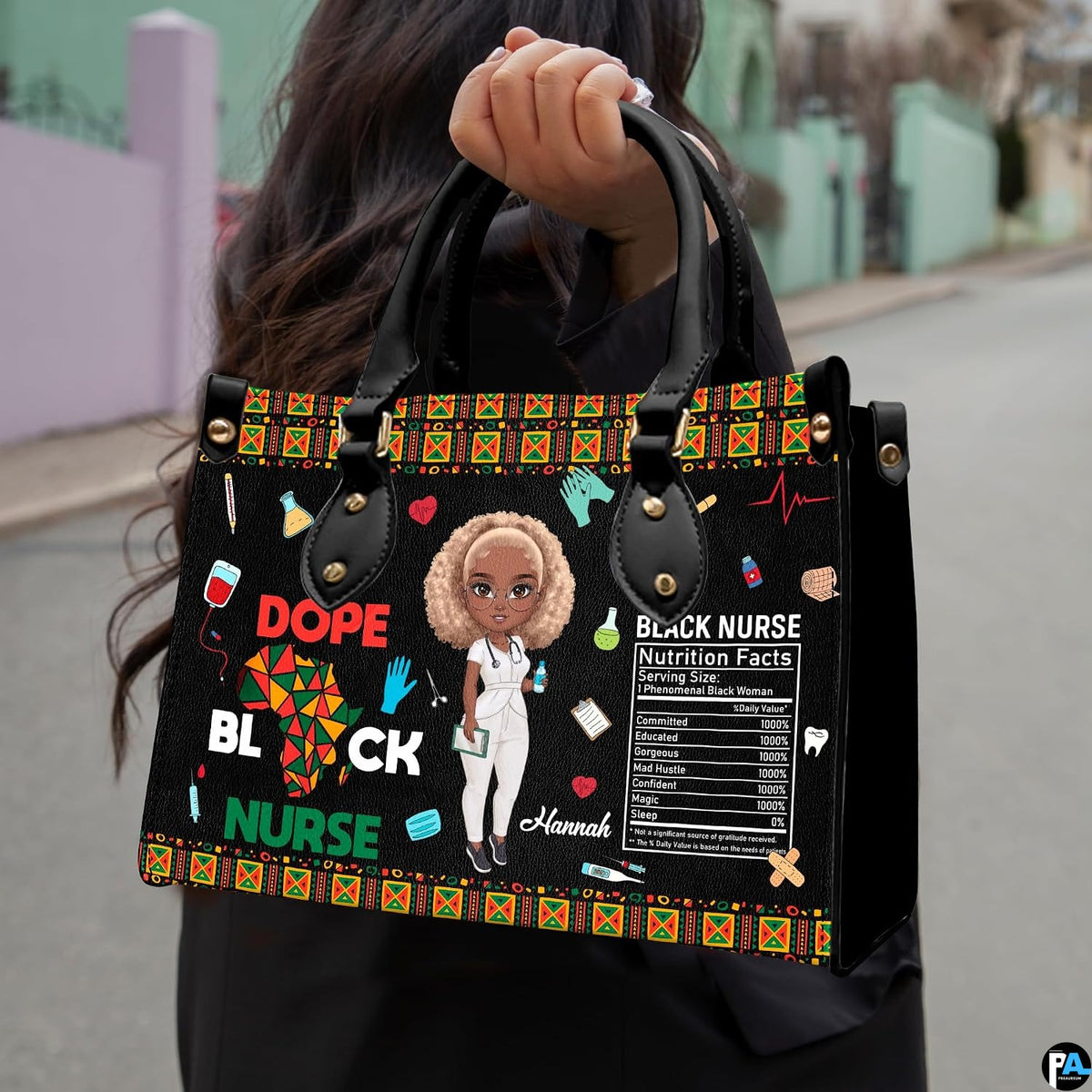 Melanin nurse handbag held outdoors showing visual scale against street setting.