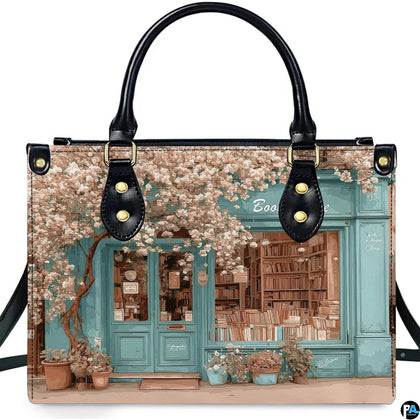 Front product view of vintage bookshop handbag displaying turquoise storefront art on pure white background.