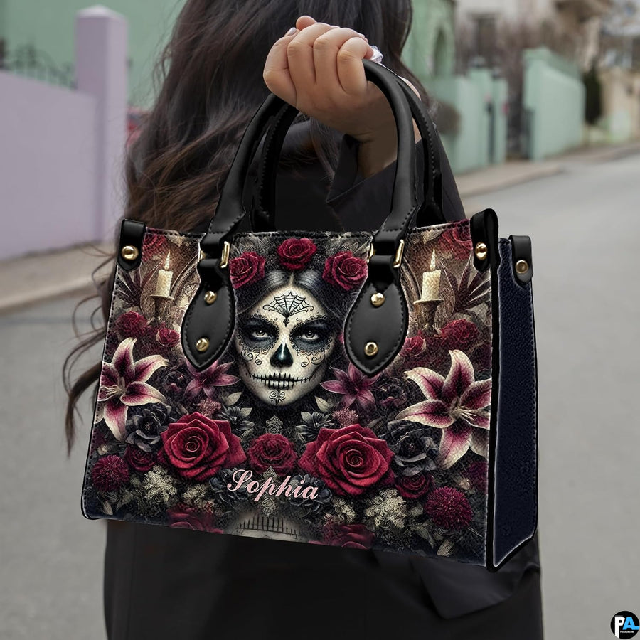 Sugar skull handbag carried by top handle while walking outdoors along a residential street.