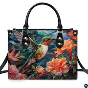 Studio front shot of mosaic hummingbird handbag showcasing outstretched wings and coral blossoms.