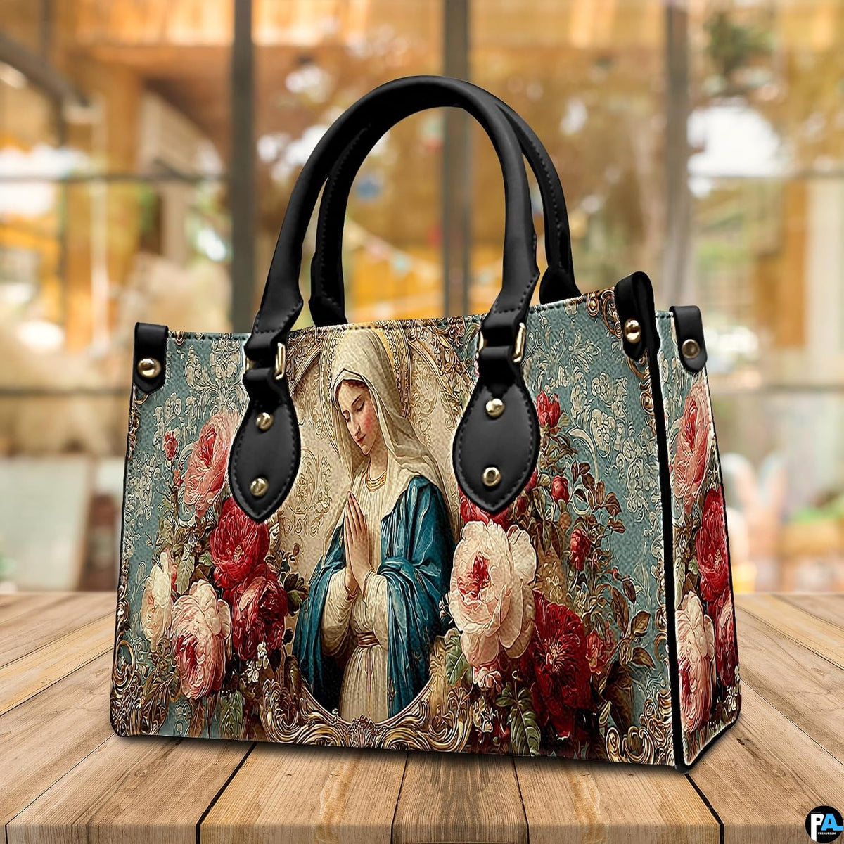 Lifestyle display showing handheld carry of the floral Virgin Mary handbag outdoors.