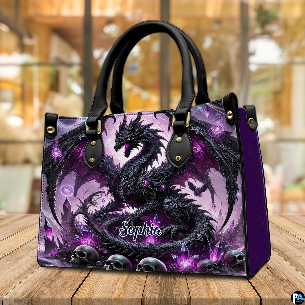 Gothic dragon handbag displayed on rustic wooden table in cafe setting.