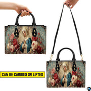 Side perspective of floral Virgin Mary handbag showing structured profile and black top handles.