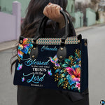 Hummingbird hibiscus handbag carried outdoors by top handle on residential street.