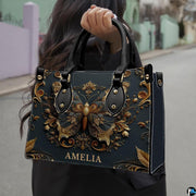 Street lifestyle view of antique gold butterfly handbag held by hand on sidewalk