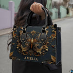Street lifestyle view of antique gold butterfly handbag held by hand on sidewalk