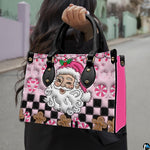 Lifestyle view showing handheld carry of pink Santa handbag outdoors.